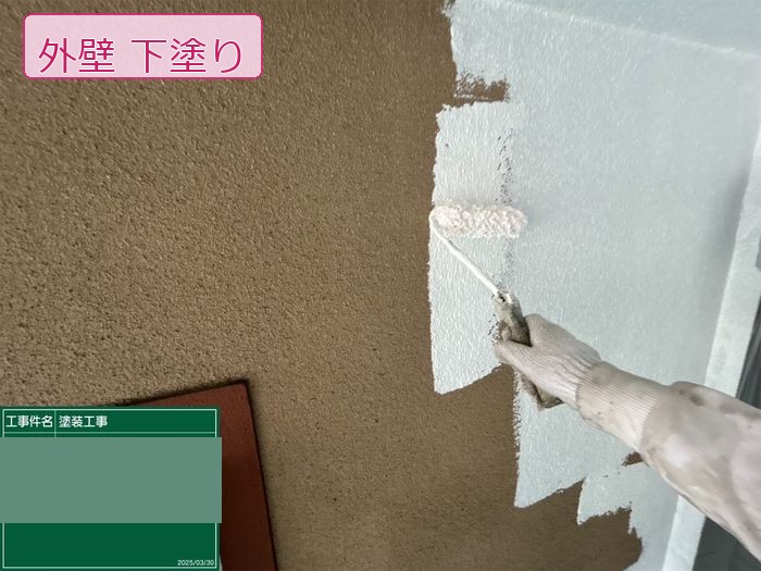 八尾市久宝寺のM様邸 フィラー下塗り施工中 白い塗料とモルタル素地の対比がわかる手元写真