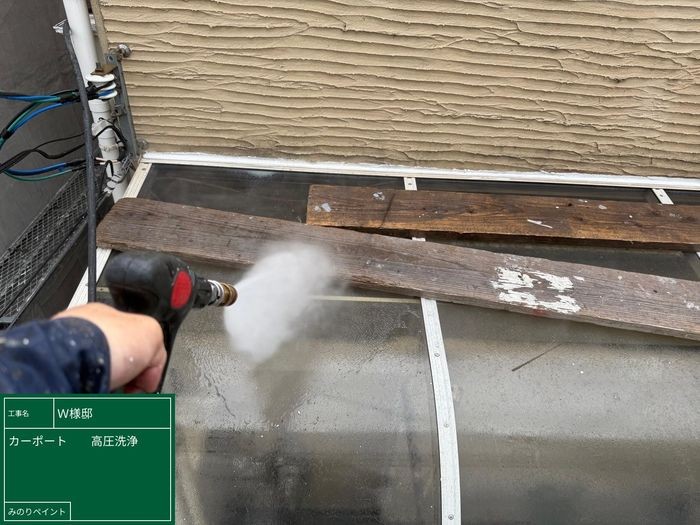羽曳野市島泉のW様邸 カーポートの木製桟と透明パネルを高圧洗浄している職人の手元