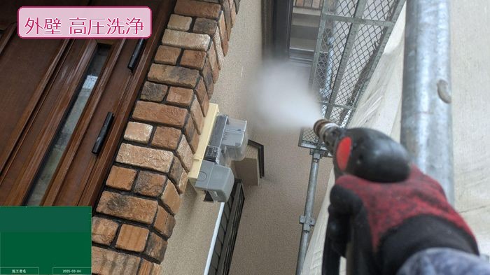 八尾市久宝寺のモルタル外壁 職人が高圧洗浄機で外壁とレンガ調タイル周辺を洗浄している様子