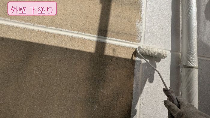 八尾市南安町のM様邸 ALC外壁の雨樋際（きわ）をローラーで丁寧に下塗りしている様子