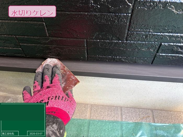 松原市別所のO様邸 水切り（外壁下部の雨水誘導板）のケレン施工中 赤いグローブの職人がやすりで表面を研磨