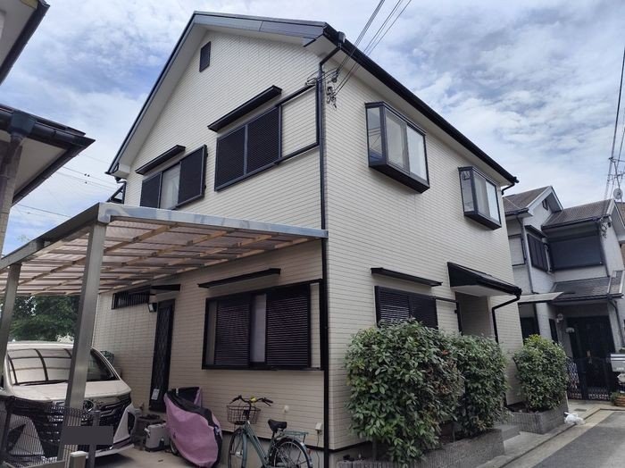 堺市東区N様邸 施工後の建物全景。明るいベージュ系の外壁と黒でまとめた付帯部