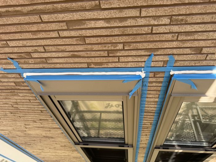 八尾市曙川東のT様邸 サイディング縦目地に新しい白いコーキングが充填されマスキングテープが貼られた状態