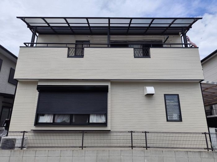 堺市東区N様邸 施工後の建物正面。ベージュ系外壁と黒系付帯部のコントラストが美しい