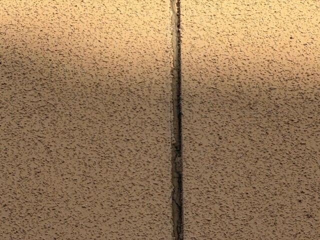 松原市別所のI様邸 モルタル外壁の縦方向の深いクラック（ひび割れ）縁が欠落している状態