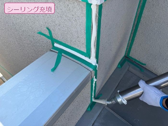 K様邸外壁出隅の取り合い部にシーリング材を充填している様子。マスキングテープで養生済み