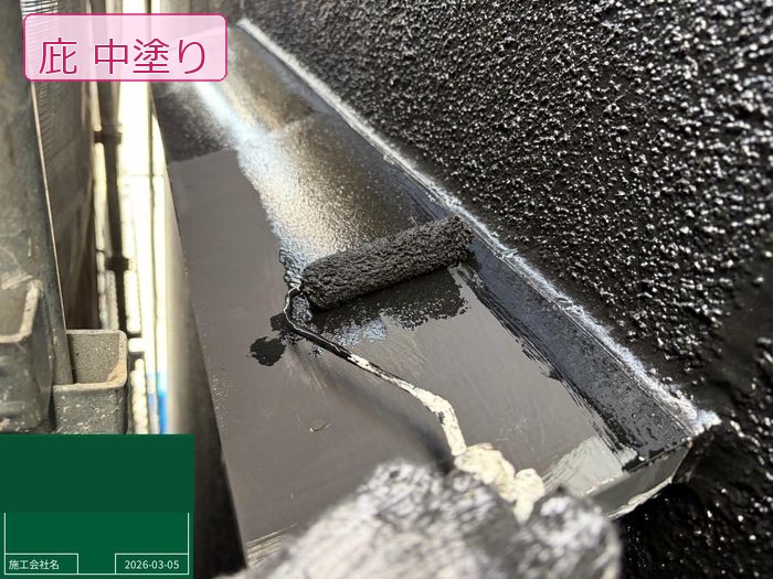 松原市別所のO様邸 庇の中塗り施工中 ローラーで塗料を均一に塗布している様子