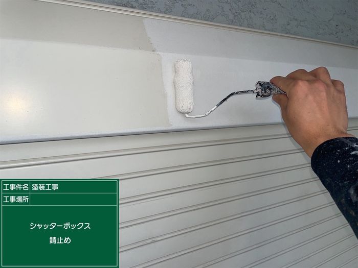 八尾市久宝寺J様邸 シャッターボックスに錆止め塗料をローラーで塗布している職人の手元