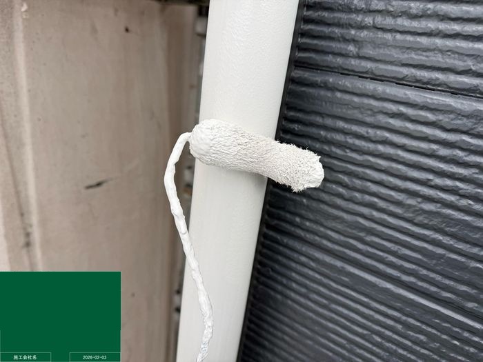 八尾市曙川東 縦樋の下塗り（ローラーで白い下塗り材を塗布）