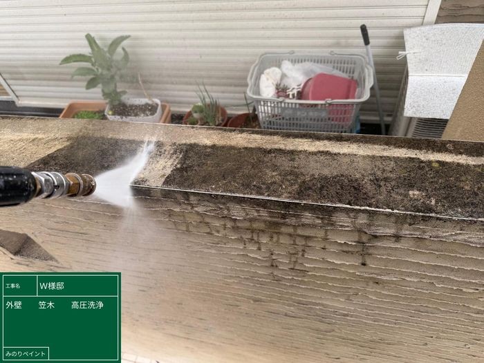 羽曳野市島泉のW様邸 外壁笠木の天端に堆積した苔・黒ずみを高圧洗浄で除去している様子