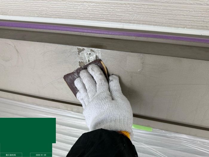 八尾市曙川東のT様邸 シャッターボックスの金属面をサンドペーパーでケレンしている職人の手元