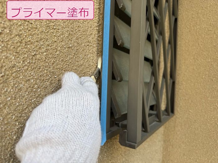 八尾市久宝寺のモルタル外壁 職人がルーバー取り合い部にプライマーを塗布している手元