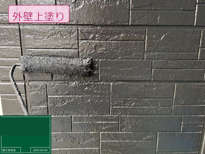 松原市別所のO様邸 石積み調サイディング外壁にチャコール系塗料で上塗りを施工中