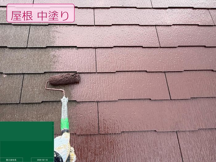 八尾市南安町M様邸 職人がローラーでスレート屋根に中塗り塗料を均一に塗り広げている様子