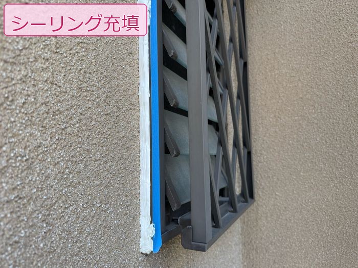 八尾市久宝寺のモルタル外壁 ルーバー取り合い部へのシーリング充填施工中の様子