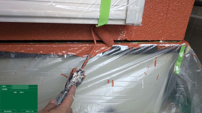 八尾市太子堂のO様邸　ブラウン外壁の中塗り　テラコッタ色の塗料を塗り際を塗っている様子